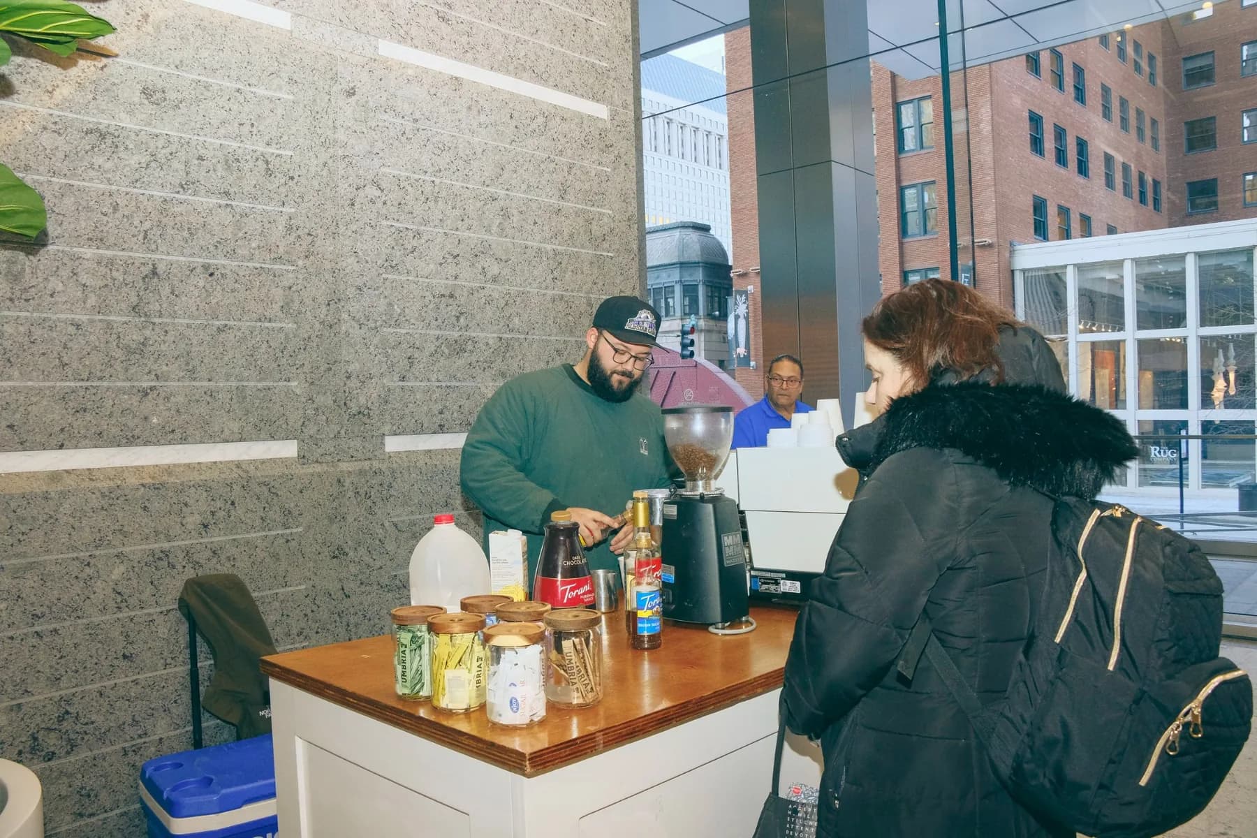 Barista making drink customer with backpack