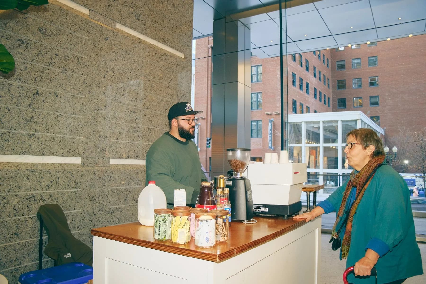 Barista talking to woman coffee cart lobby