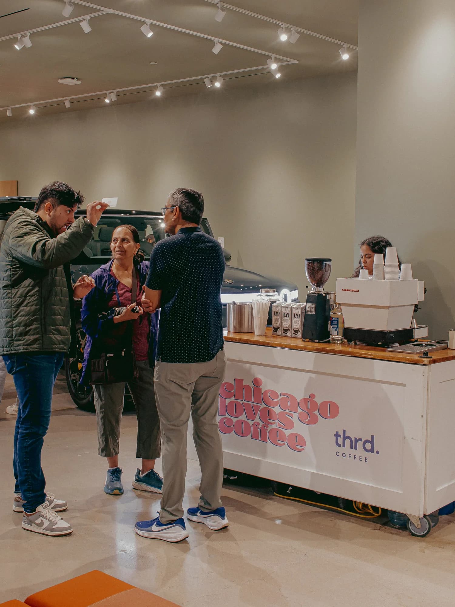 Guests talking beside the thrd coffee cart at the Rivian showroom event