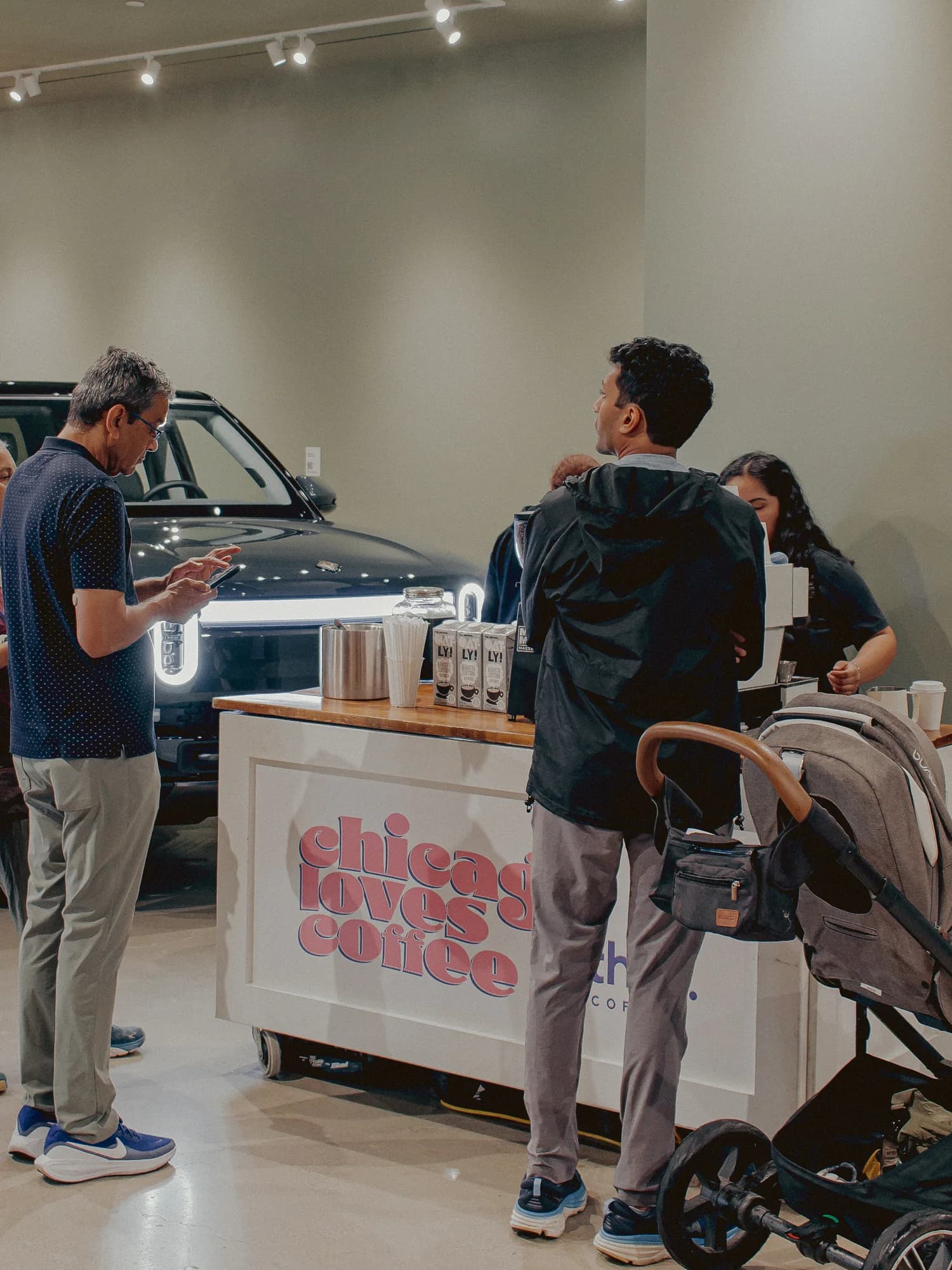 Guests ordering espresso drinks at the thrd coffee cart on the Rivian showroom floor